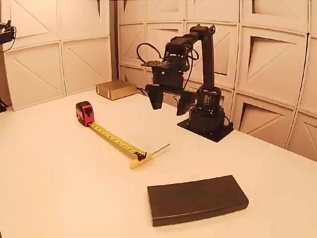 AA-Robotics test: robot arm measuring an object with a tape measure (Artificial Analysis)