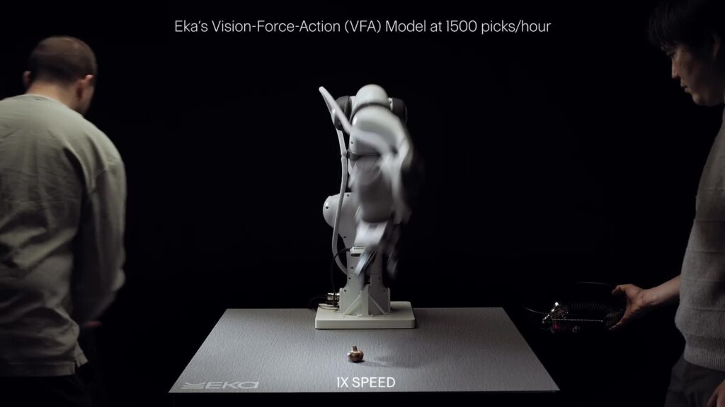The same demo a few seconds later: the arm moves objects across the table (Eka Robotics, video still)