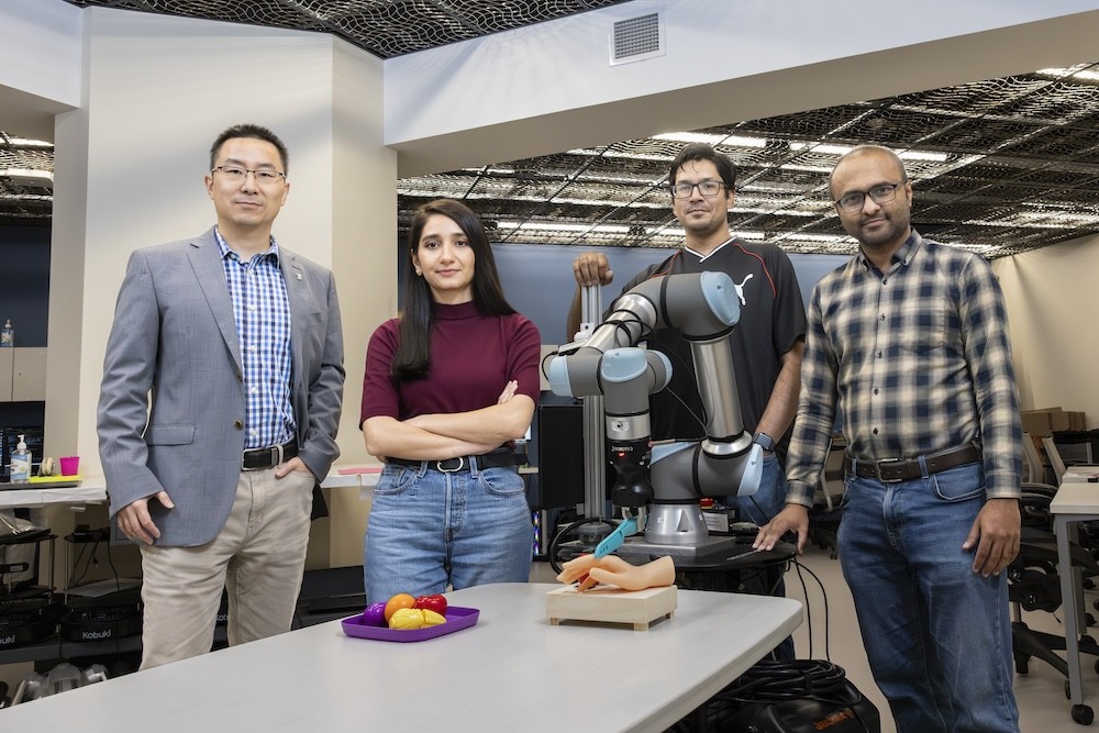 Binghamton researchers Shiqi Zhang, Zainab Altaweel, Mohaiminul Al Nahian and Adnan Siraj Rakin with their test robot (Binghamton University)