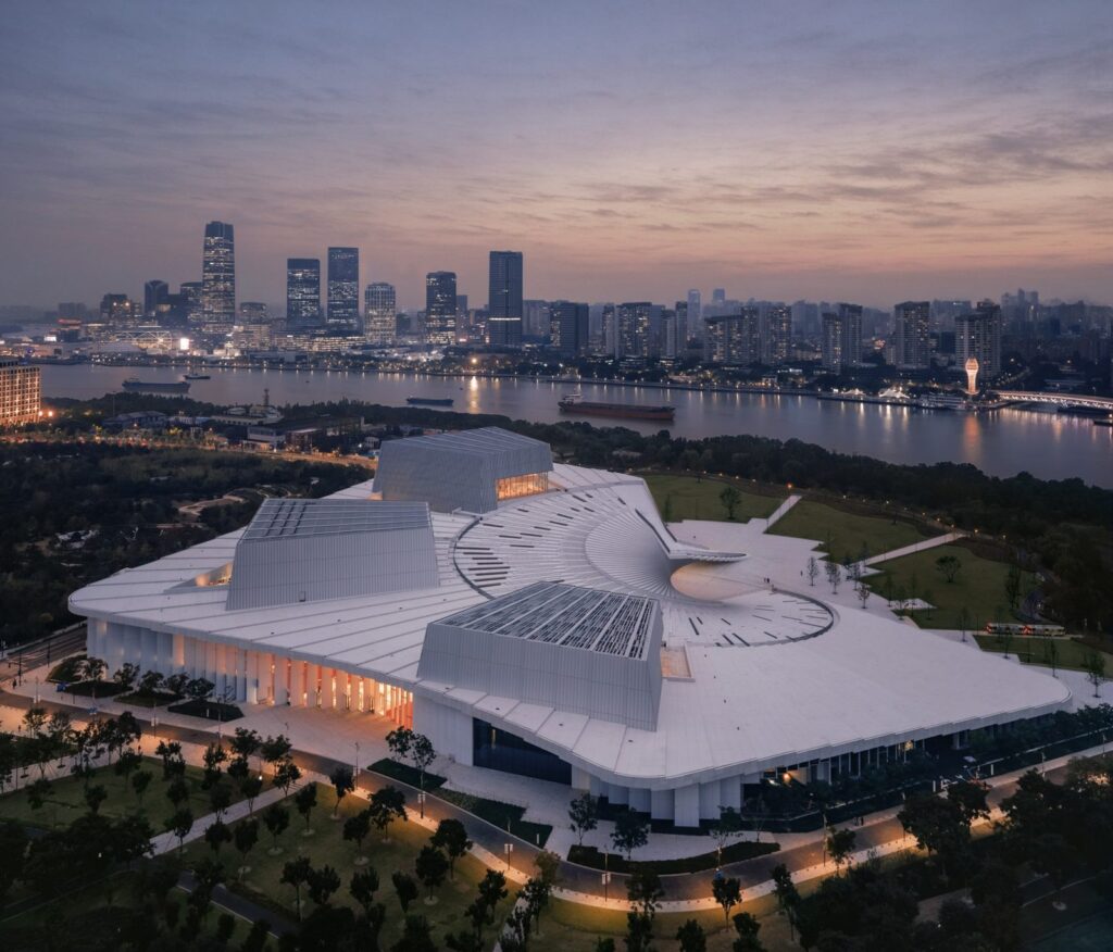 Aerial view of the Shanghai Grand Opera House on the Huangpu River at dusk (Snøhetta via Dezeen)